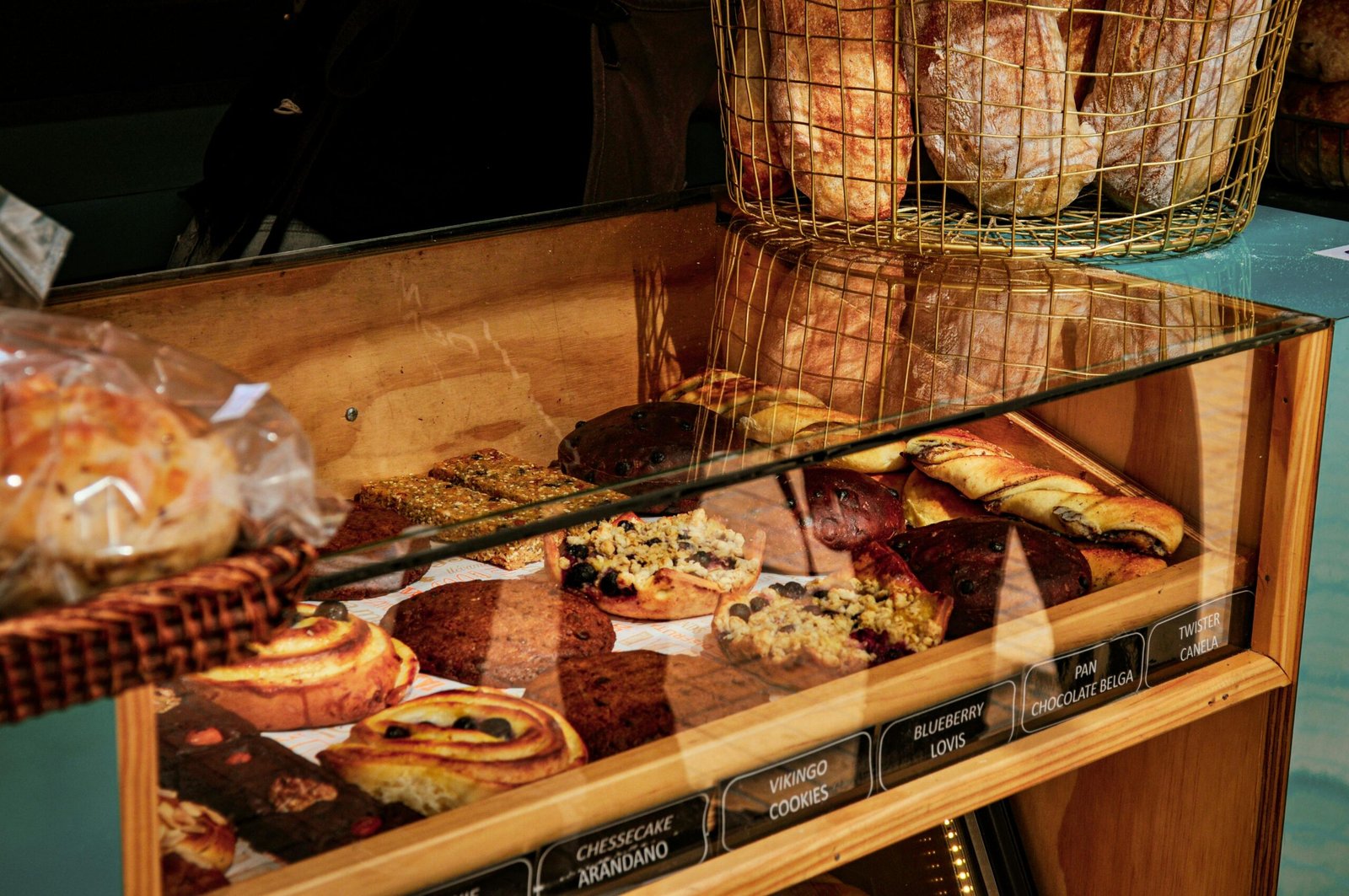 A close-up of assorted pastries and bread in a bakery display in Santiago de Chile.